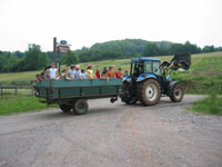 Mit Traktor und Anhänger geht es mit den Gästekinder zum Tagesausflug